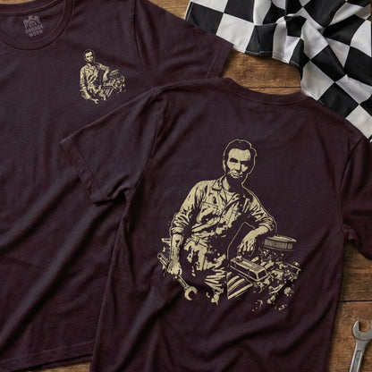 Abraham Lincoln tinkering with an engine on a dark t-shirt.