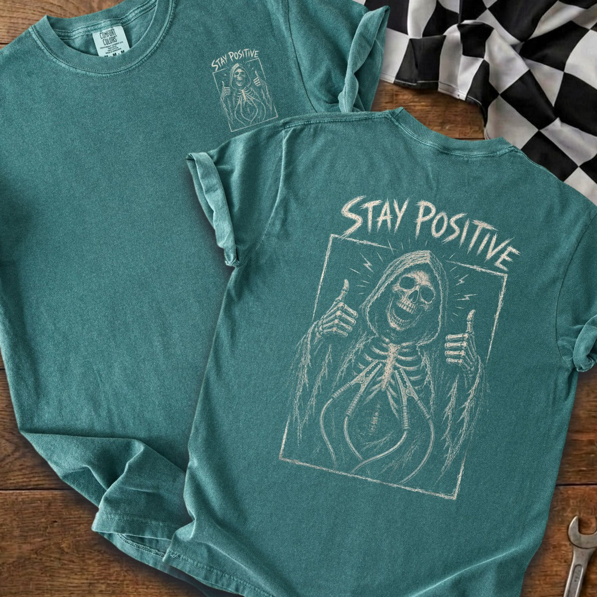 Teal t-shirt featuring a grim reaper graphic and "Stay Positive" text.