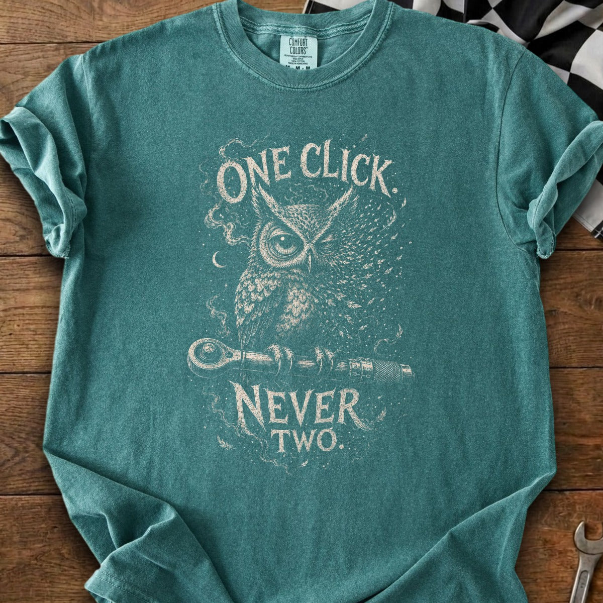 Teal t-shirt with an owl holding a wrench, text reads "ONE CLICK NEVER TWO."