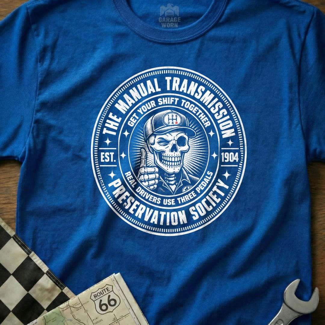 Blue t-shirt with "The Manual Transmission Preservation Society" circular graphic featuring a skeleton.