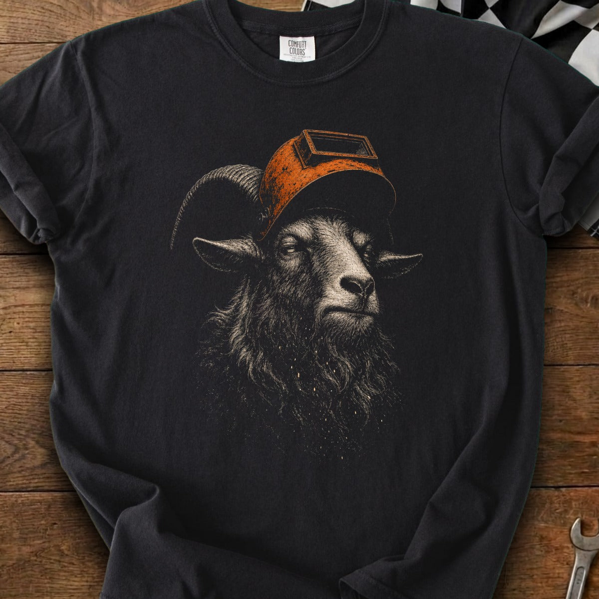 Black t-shirt with a detailed illustration of a ram wearing an orange welding mask.