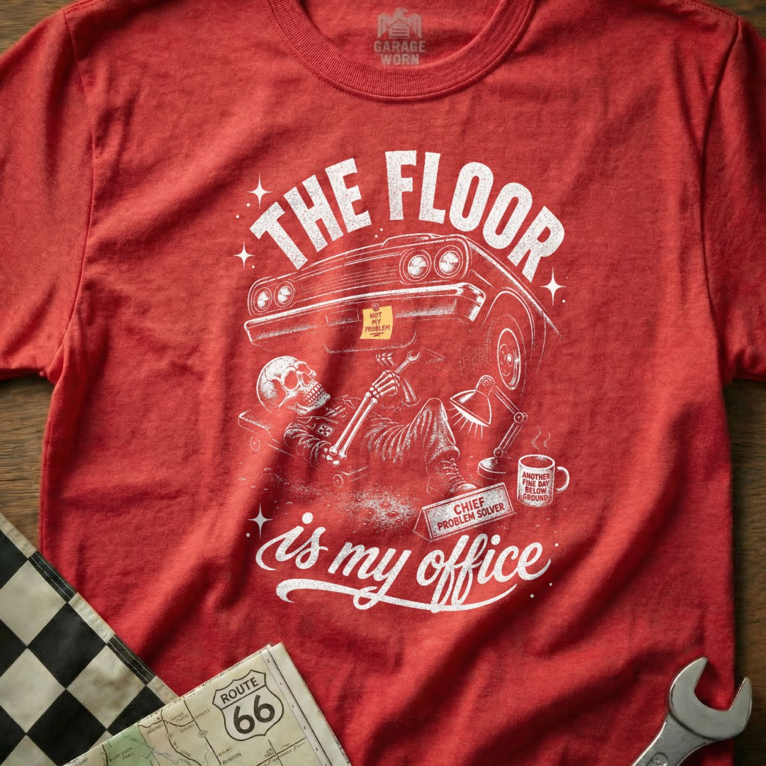 Red t-shirt with graphic of skeleton under car, text "The Floor is My Office".