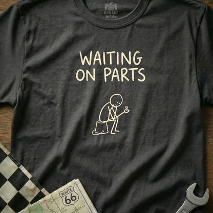 Dark gray t-shirt with "WAITING ON PARTS" text and a stick figure holding a bolt.