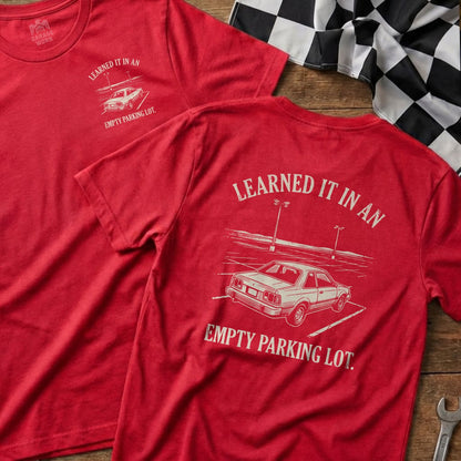 Red t-shirt with text "Learned it in an empty parking lot" and car graphic.