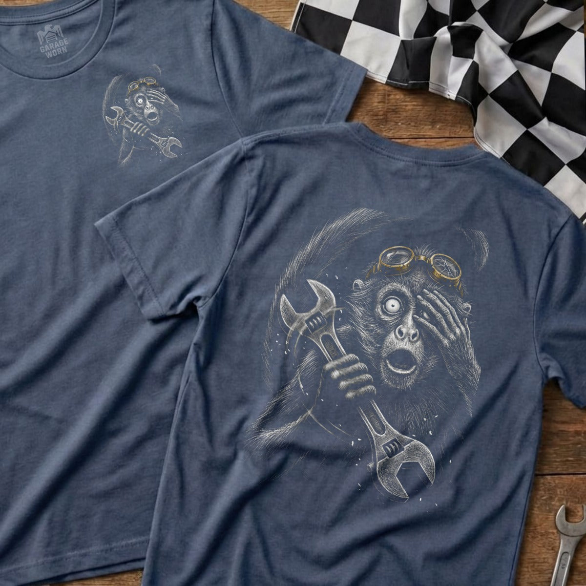 T-shirt with a surprised monkey wearing goggles holding a wrench.
