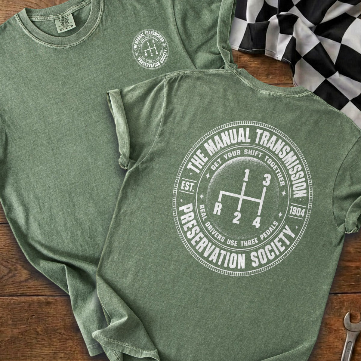 Green t-shirt with "The Manual Transmission Preservation Society" and gear shift graphic.