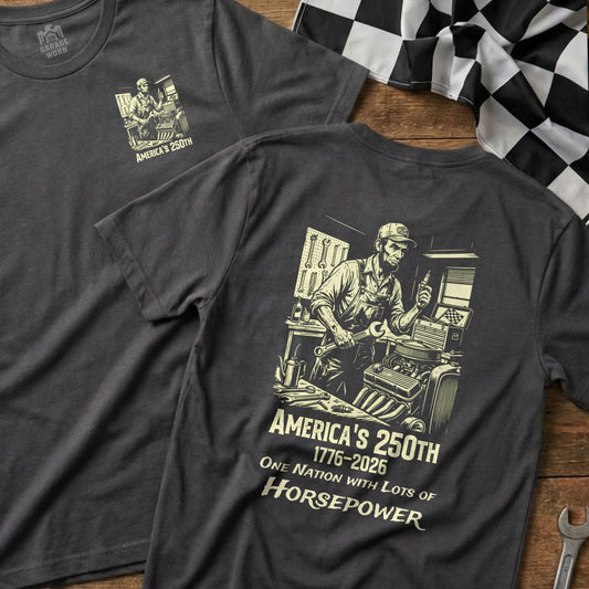 Dark grey t-shirt with illustration of a mechanic and text "America's 250th 1776-2026 One Nation with Lots of Horsepower".