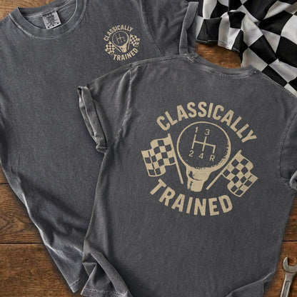 Dark grey t-shirt with "CLASSICALLY TRAINED" text and gear shift graphic with checkered flags.