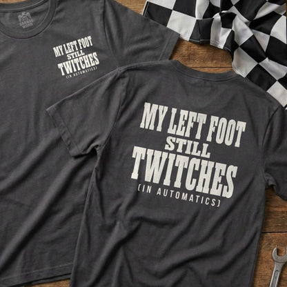 Dark t-shirt with white text "MY LEFT FOOT STILL TWITCHES (IN AUTOMATICS)".