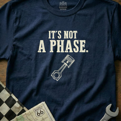 Navy t-shirt with white text "It's not a phase." and a piston graphic.