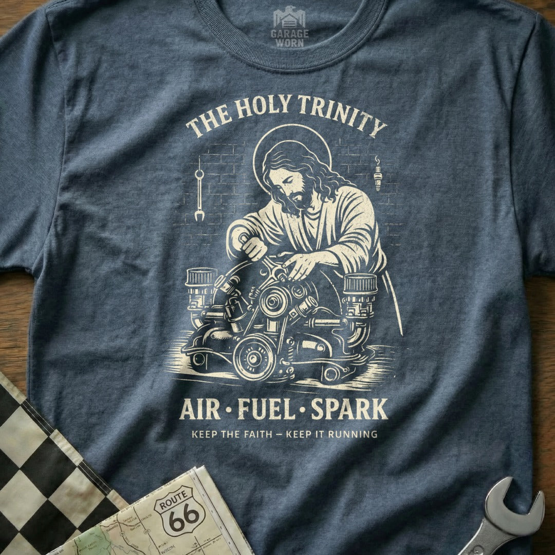 Jesus working on an engine with "The Holy Trinity" and "Air Fuel Spark" text.