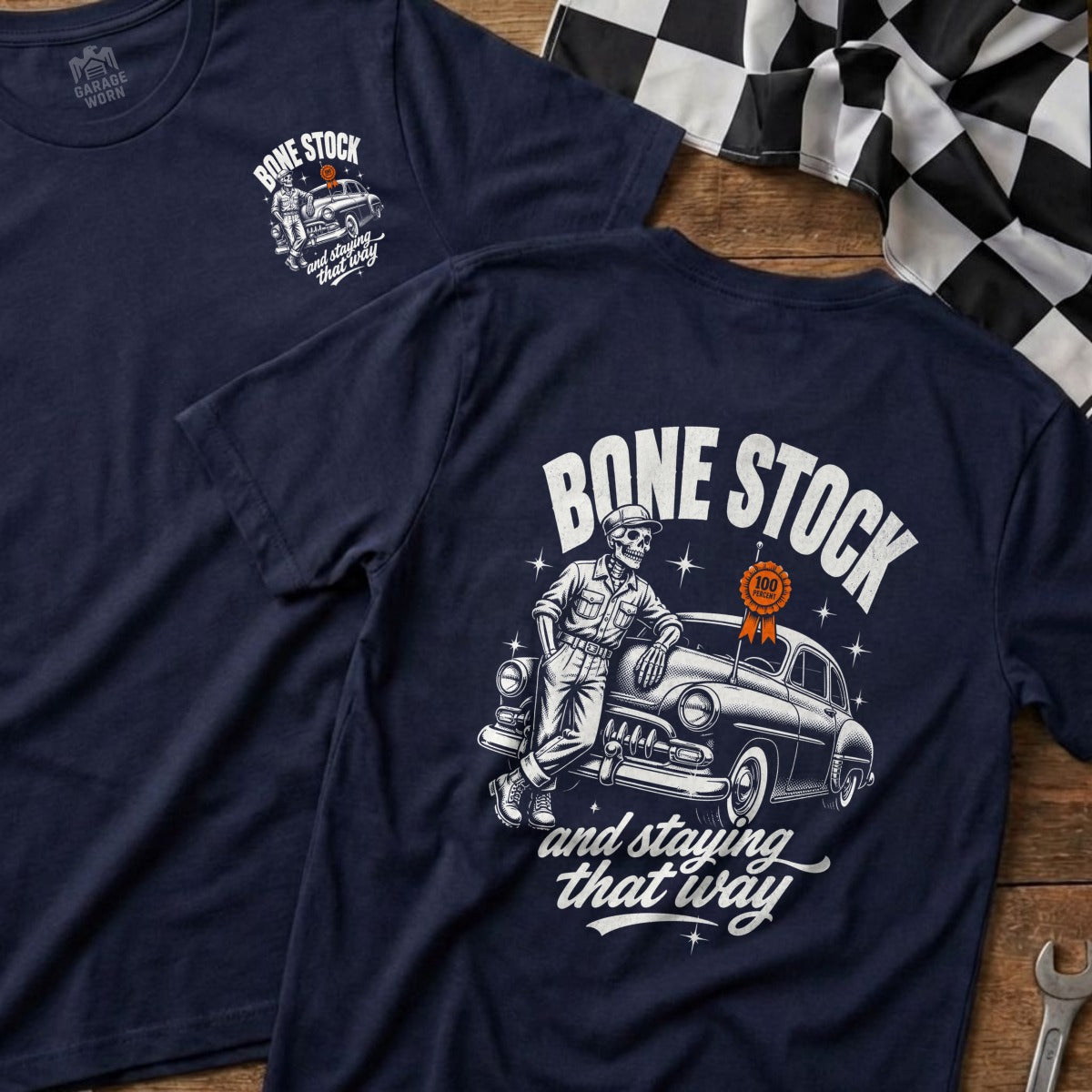 Navy t-shirt with a skeleton leaning on a vintage car, reads "Bone Stock".