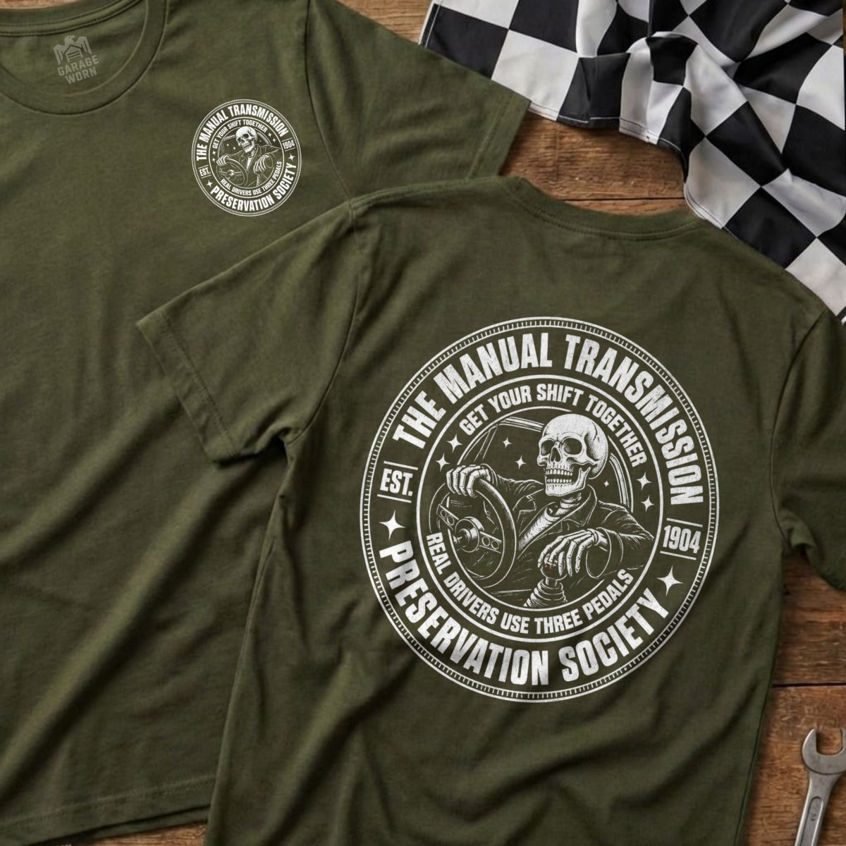 Green t-shirt with skeleton driving, "The Manual Transmission Preservation Society" text.