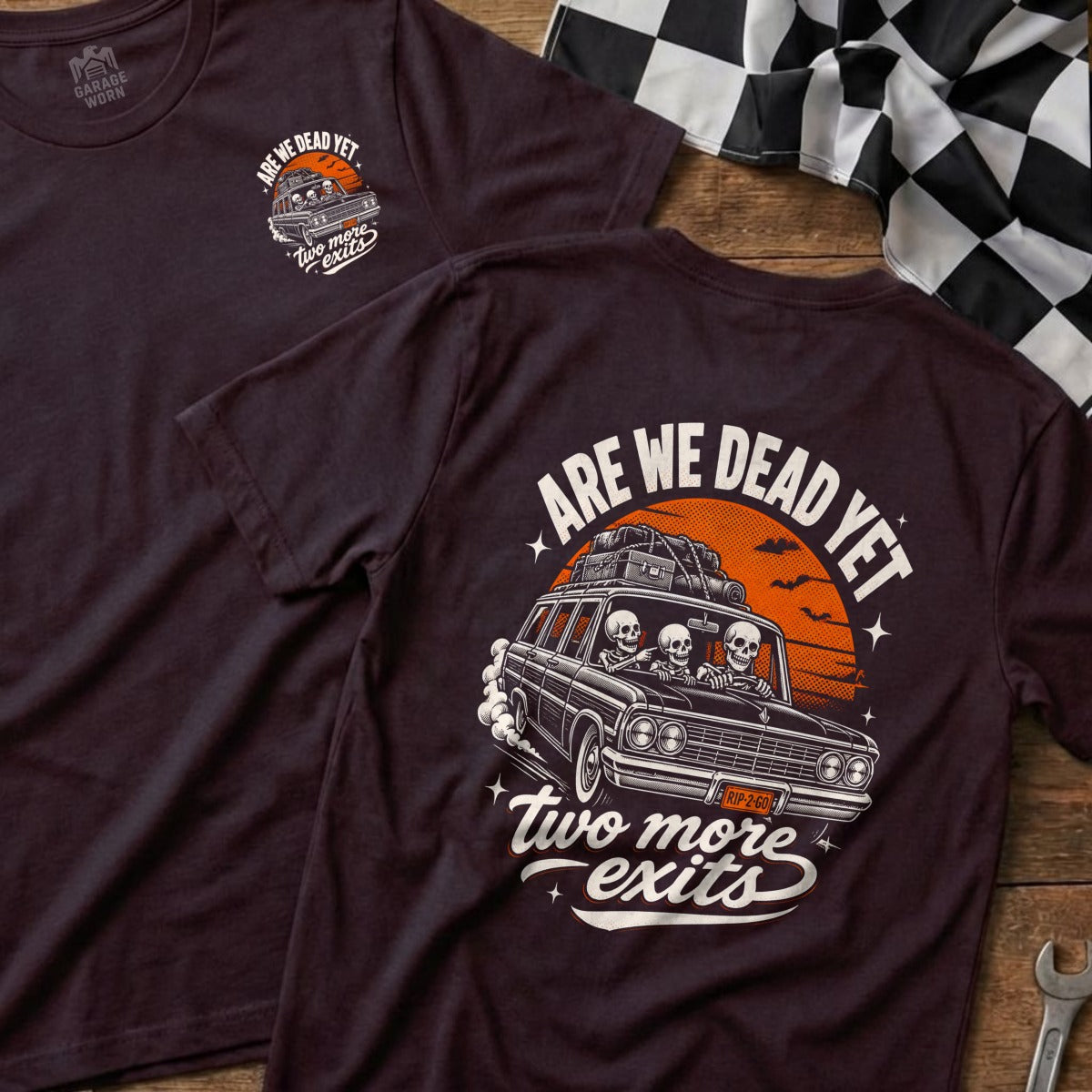 T-shirt graphic with skeletons in a car, "Are We Dead Yet," and "Two More Exits."