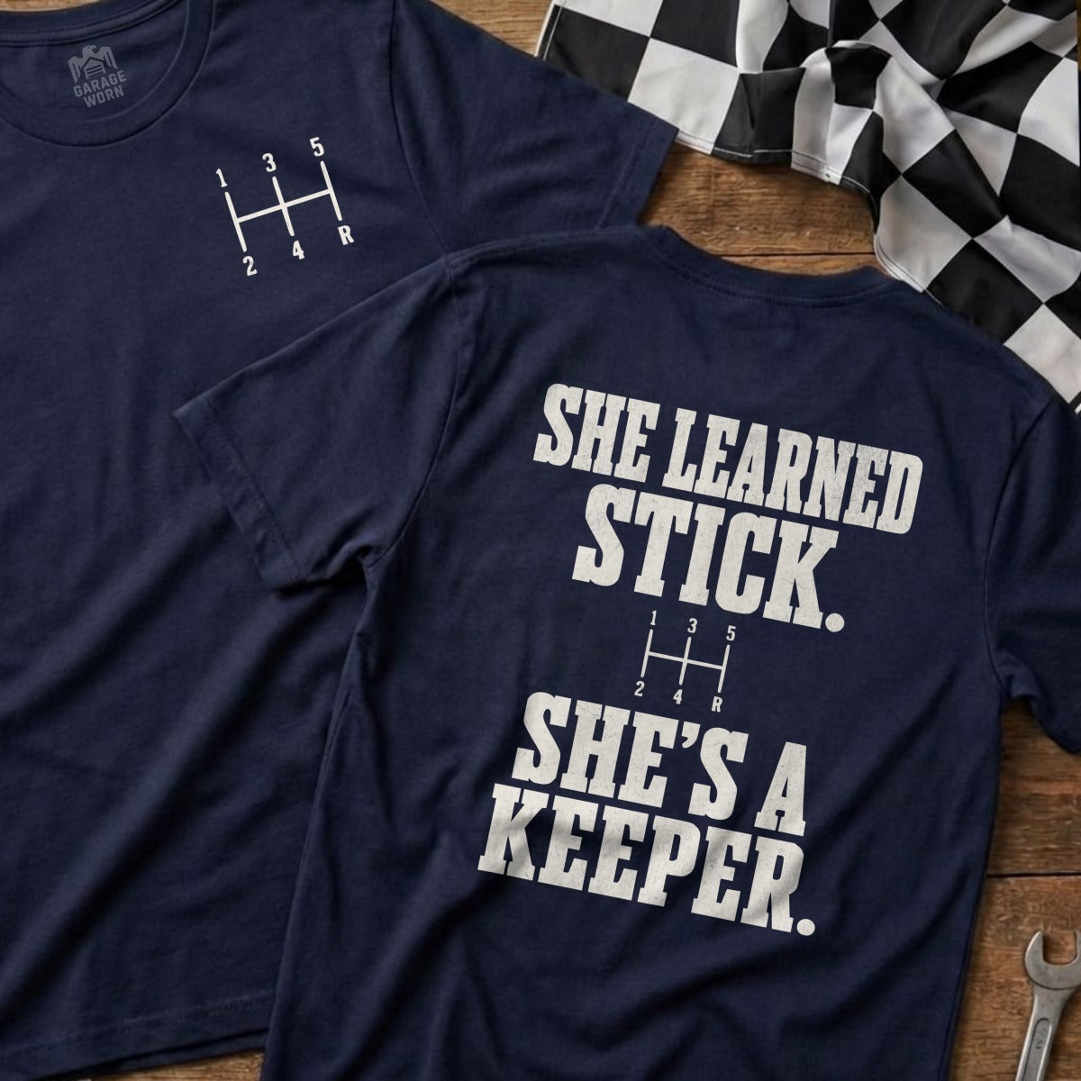 Navy t-shirt with a 5-speed gear shift pattern and "She Learned Stick" text.
