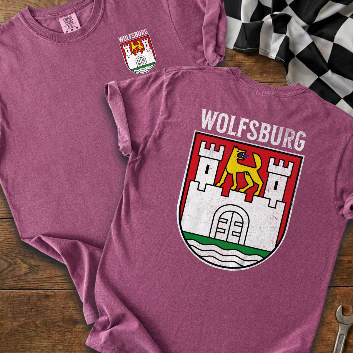 Two pink t-shirts displayed, one with Wolfsburg crest on front, other with crest and text on back.