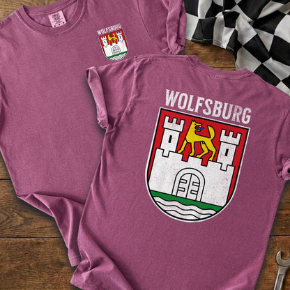 Two pink t-shirts displayed, one with Wolfsburg crest on front, other with crest and text on back.