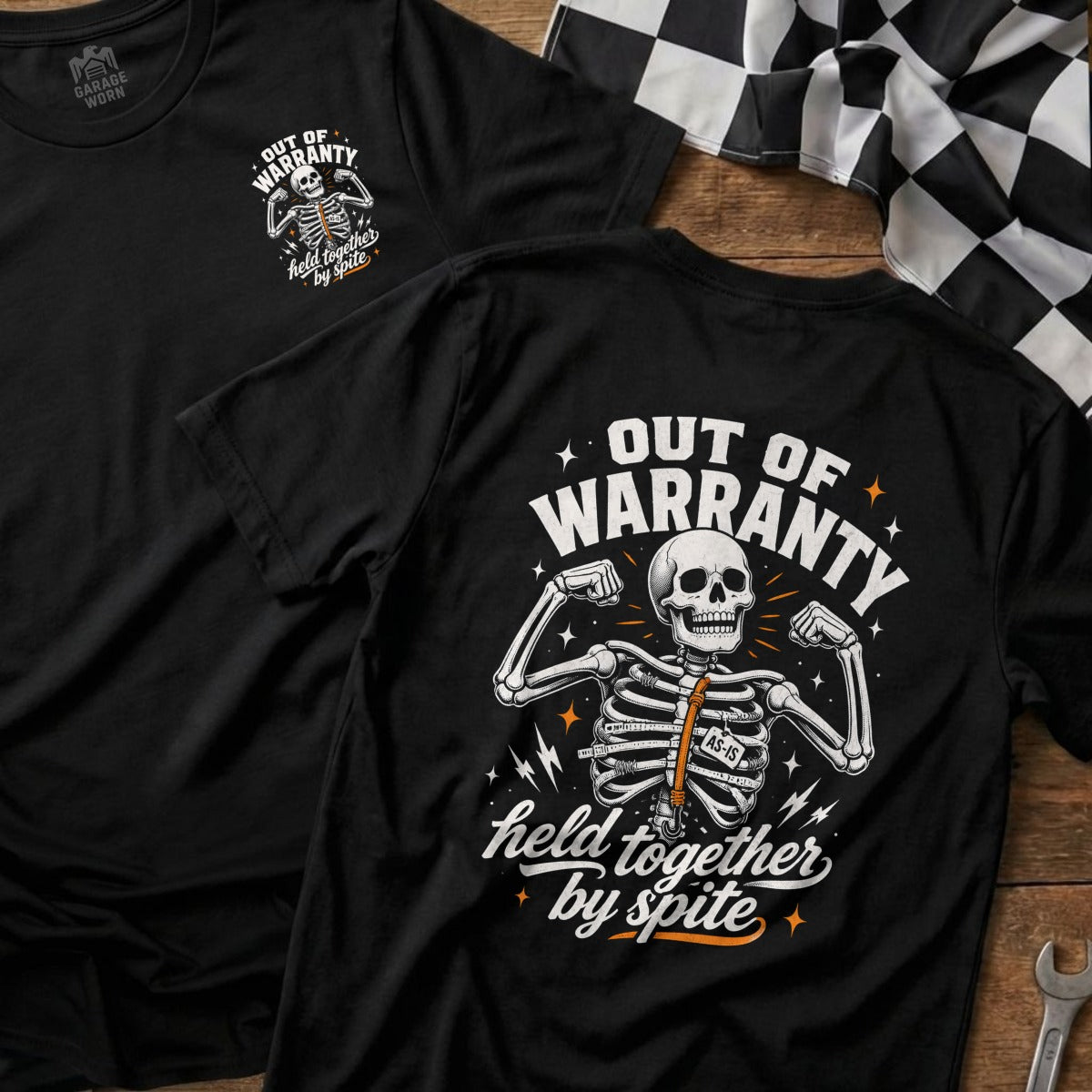 Black t-shirt with "Out of Warranty, Held Together by Spite" skeleton graphic.
