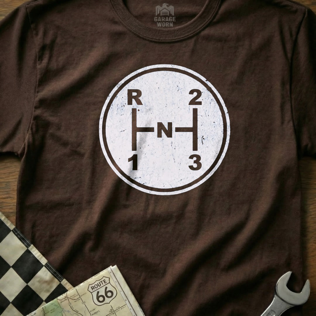 Brown t-shirt with white manual gear shift pattern: R, N, 1, 2, 3.