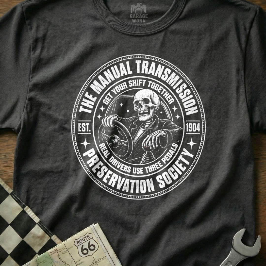 Graphic tee with skeleton driving, "The Manual Transmission Preservation Society" text around it.