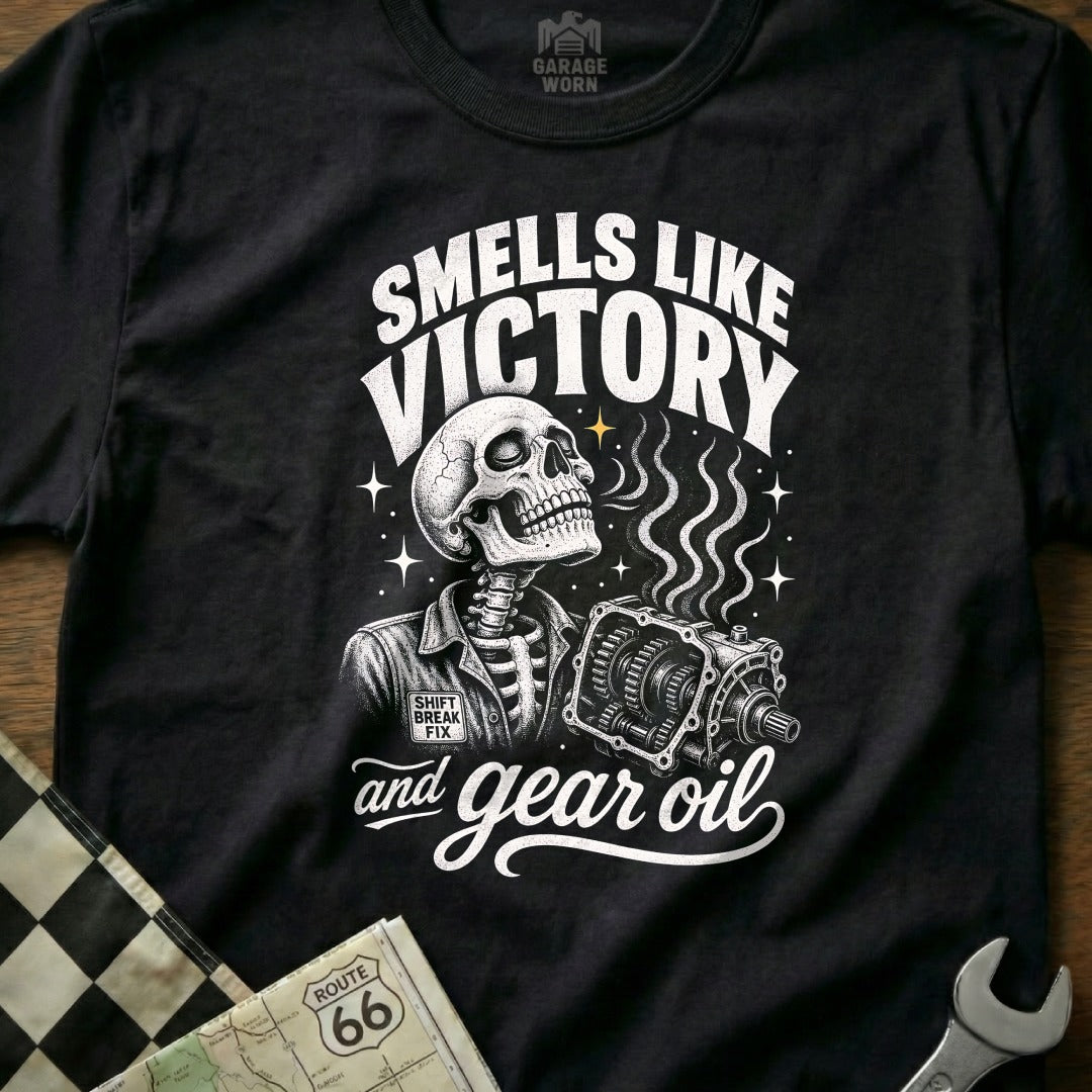 Black t-shirt design with a skeleton holding a gearbox and the text "Smells Like Victory and Gear Oil".