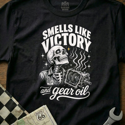Black t-shirt design with a skeleton holding a gearbox and the text "Smells Like Victory and Gear Oil".
