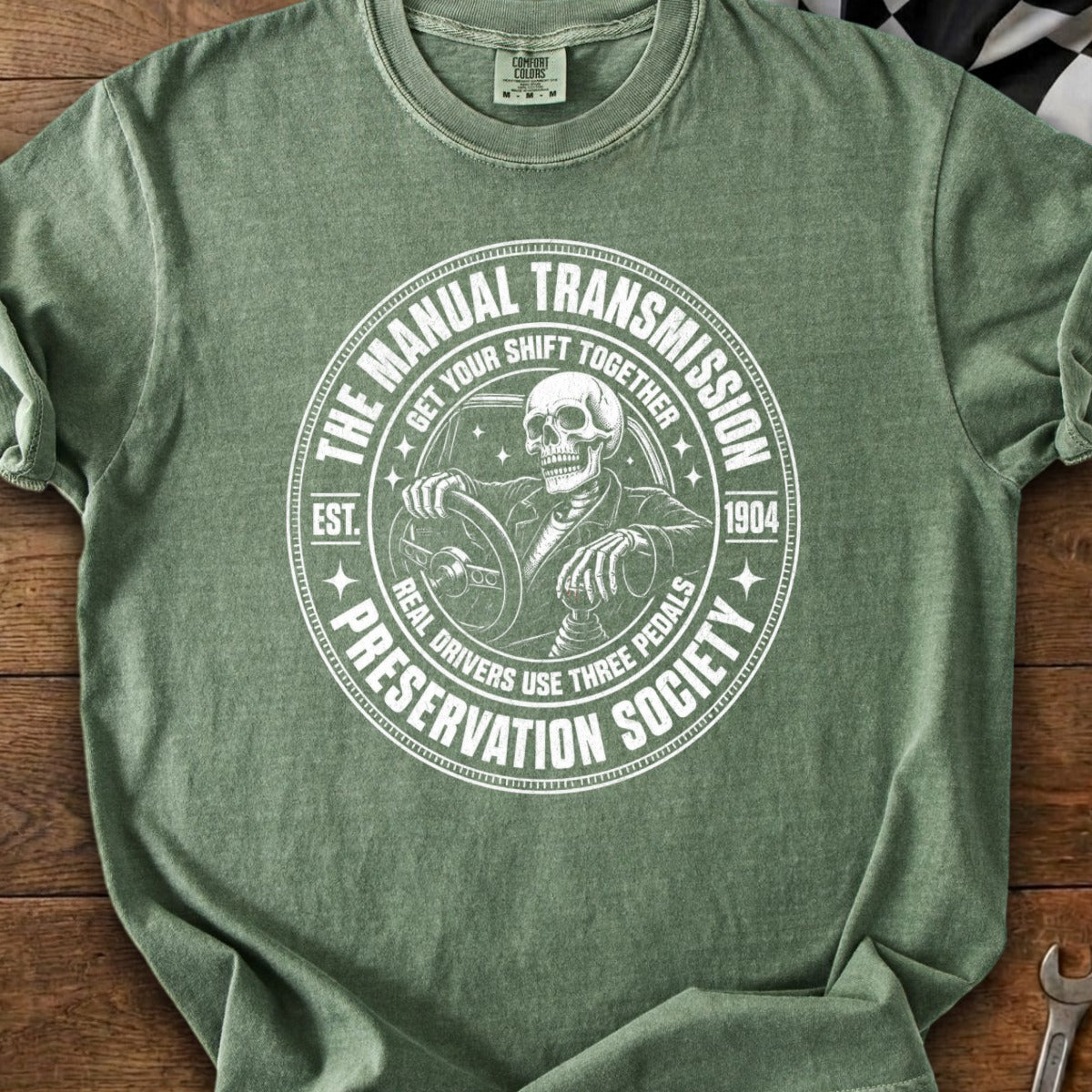 Skeleton driving a car with "The Manual Transmission Preservation Society" text.