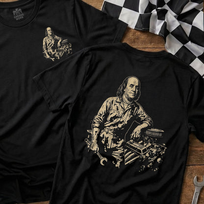 T-shirt with Benjamin Franklin leaning on car engine, holding wrench.