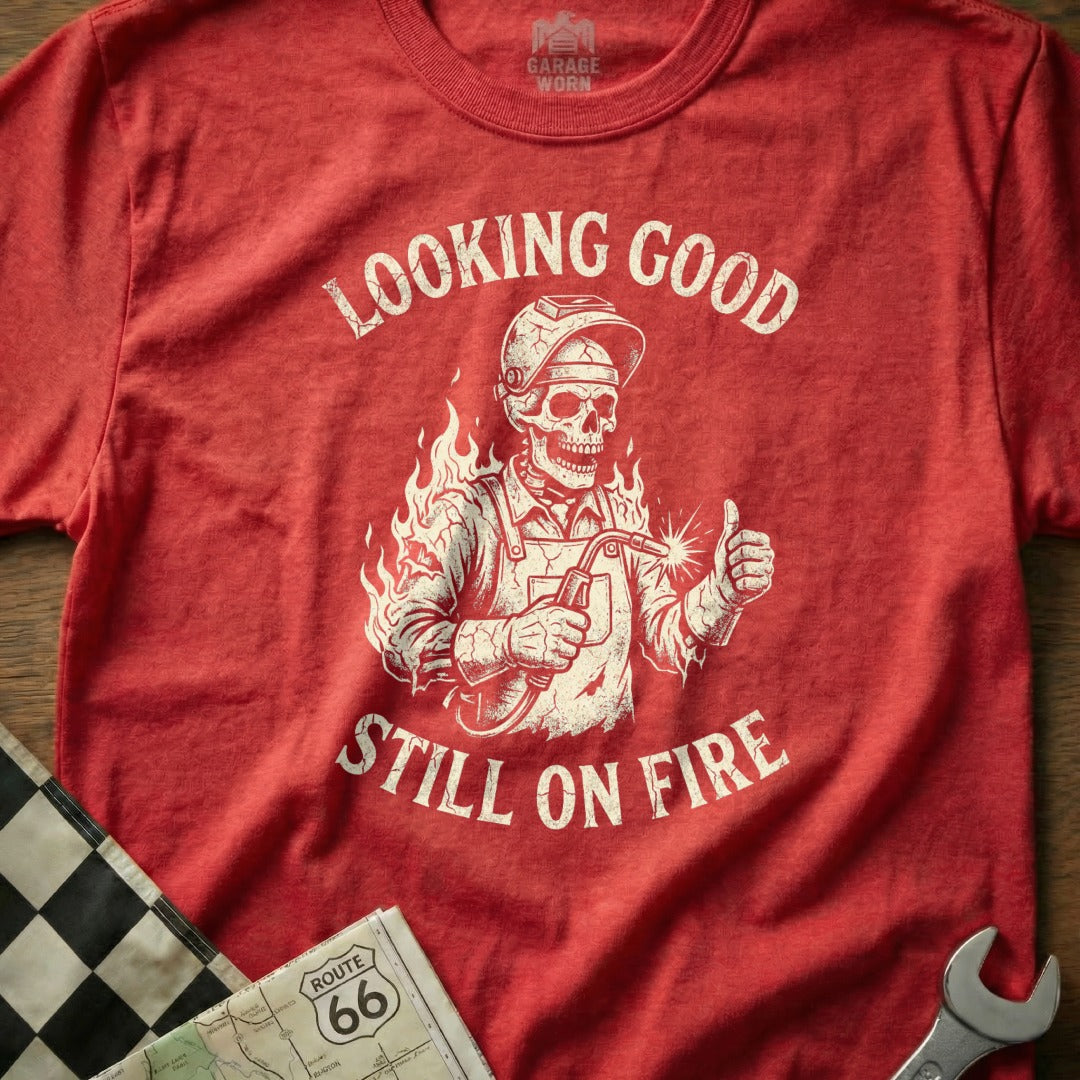 T-shirt with skeleton welder giving thumbs up and text "Looking Good Still On Fire".