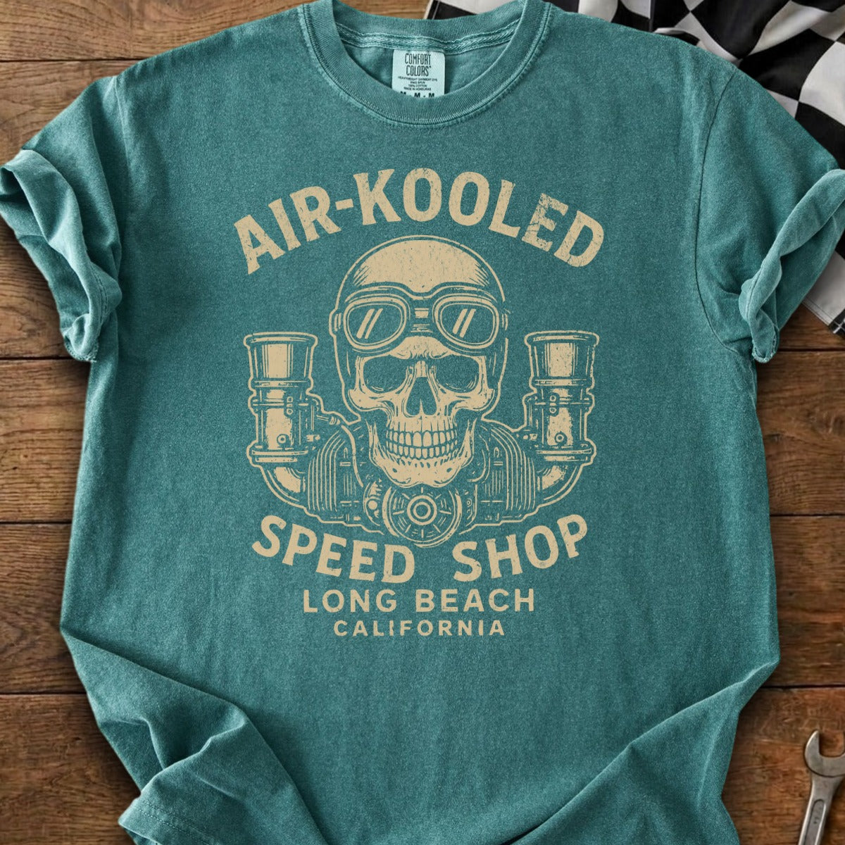 Teal t-shirt with vintage skull, goggles, and engines graphic.