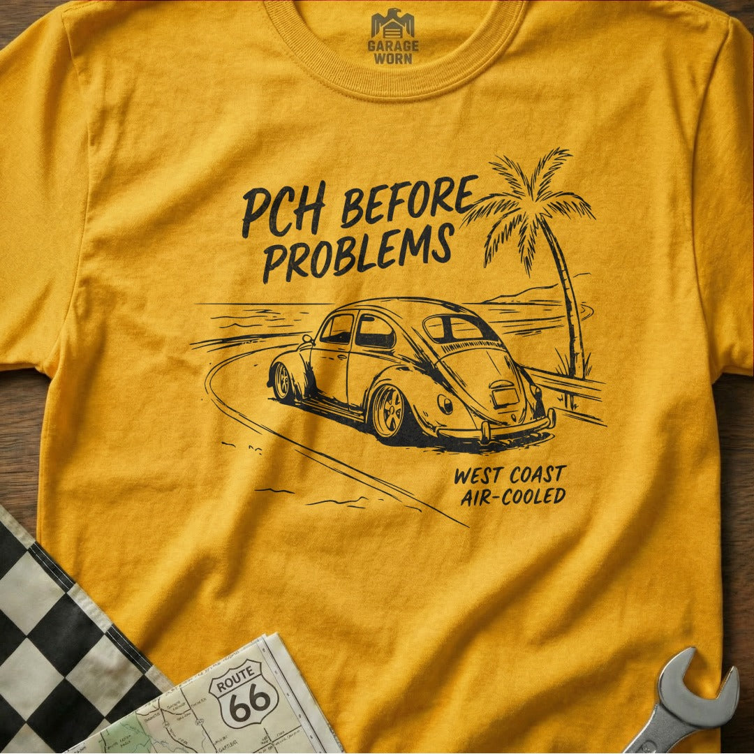 Yellow t-shirt with sketch of a VW Beetle on a coastal road, "PCH BEFORE PROBLEMS" text.