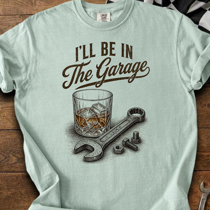T-shirt with text "I'll Be In The Garage" and illustration of a wrench and a drink.