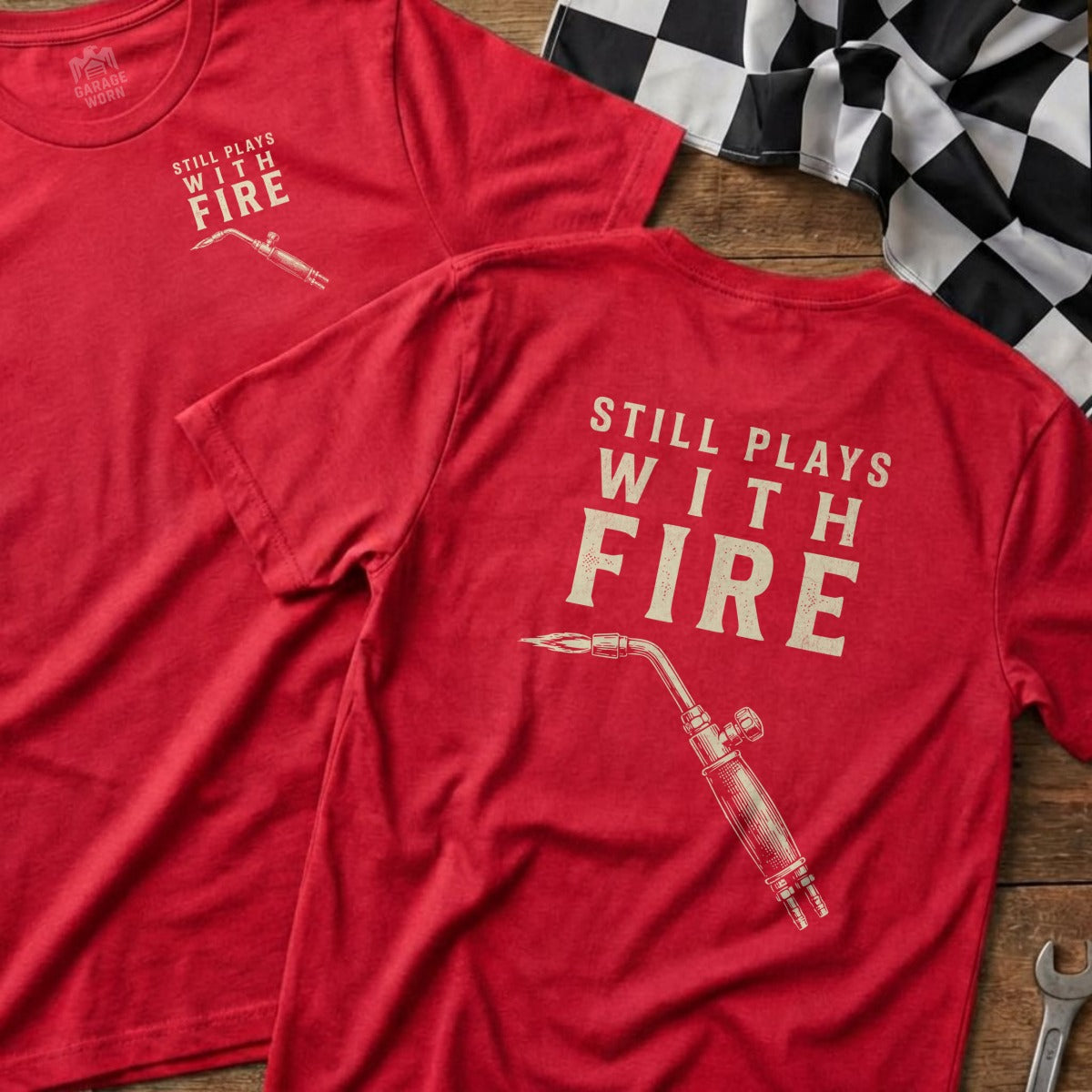 Red t-shirt with "STILL PLAYS WITH FIRE" and a welding torch graphic.