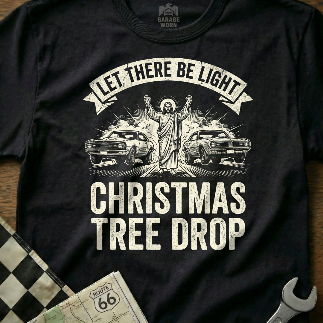 Black t-shirt with Jesus between two muscle cars, reading "Let There Be Light Christmas Tree Drop".
