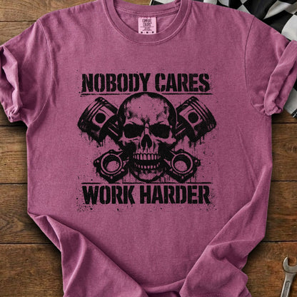 T-shirt with skull, pistons, "Nobody Cares," and "Work Harder" text.