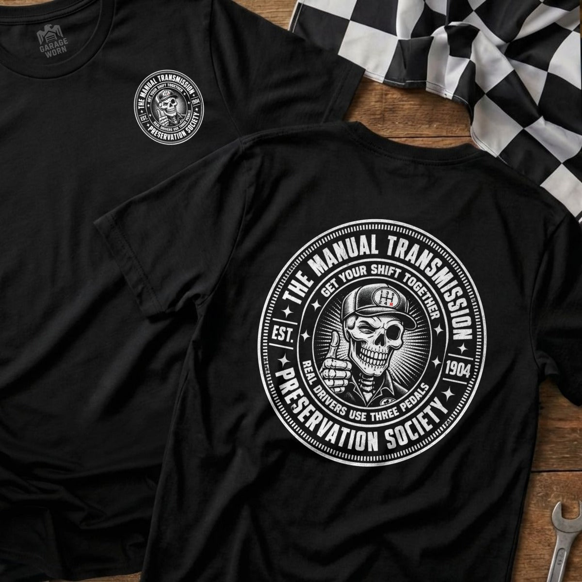 Black t-shirt with circular "Manual Transmission Preservation Society" graphic featuring a skull.