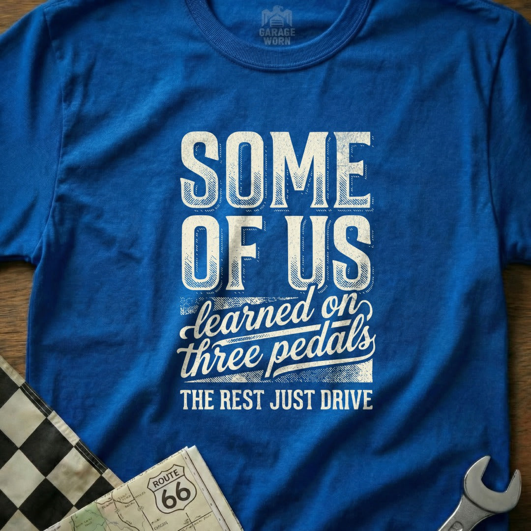 Blue t-shirt with "SOME OF US learned on three pedals THE REST JUST DRIVE" text.