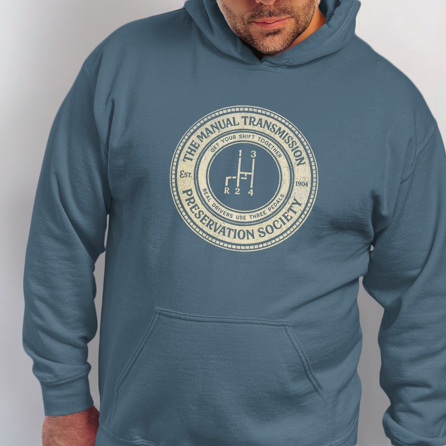 Blue hoodie with "The Manual Transmission Preservation Society" logo featuring a gear shift.