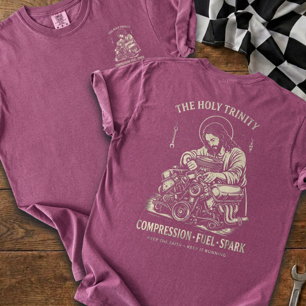 Maroon t-shirt with Jesus working on an engine, "The Holy Trinity" and "Compression Fuel Spark" text.