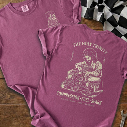 Maroon t-shirt with Jesus working on an engine, "The Holy Trinity" and "Compression Fuel Spark" text.