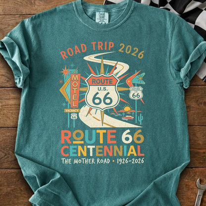 Teal t-shirt with Route 66 Centennial design, "Road Trip 2026" and "The Mother Road 1926-2026".