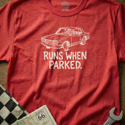 Red t-shirt with white graphic of a vintage car and text "RUNS WHEN PARKED."