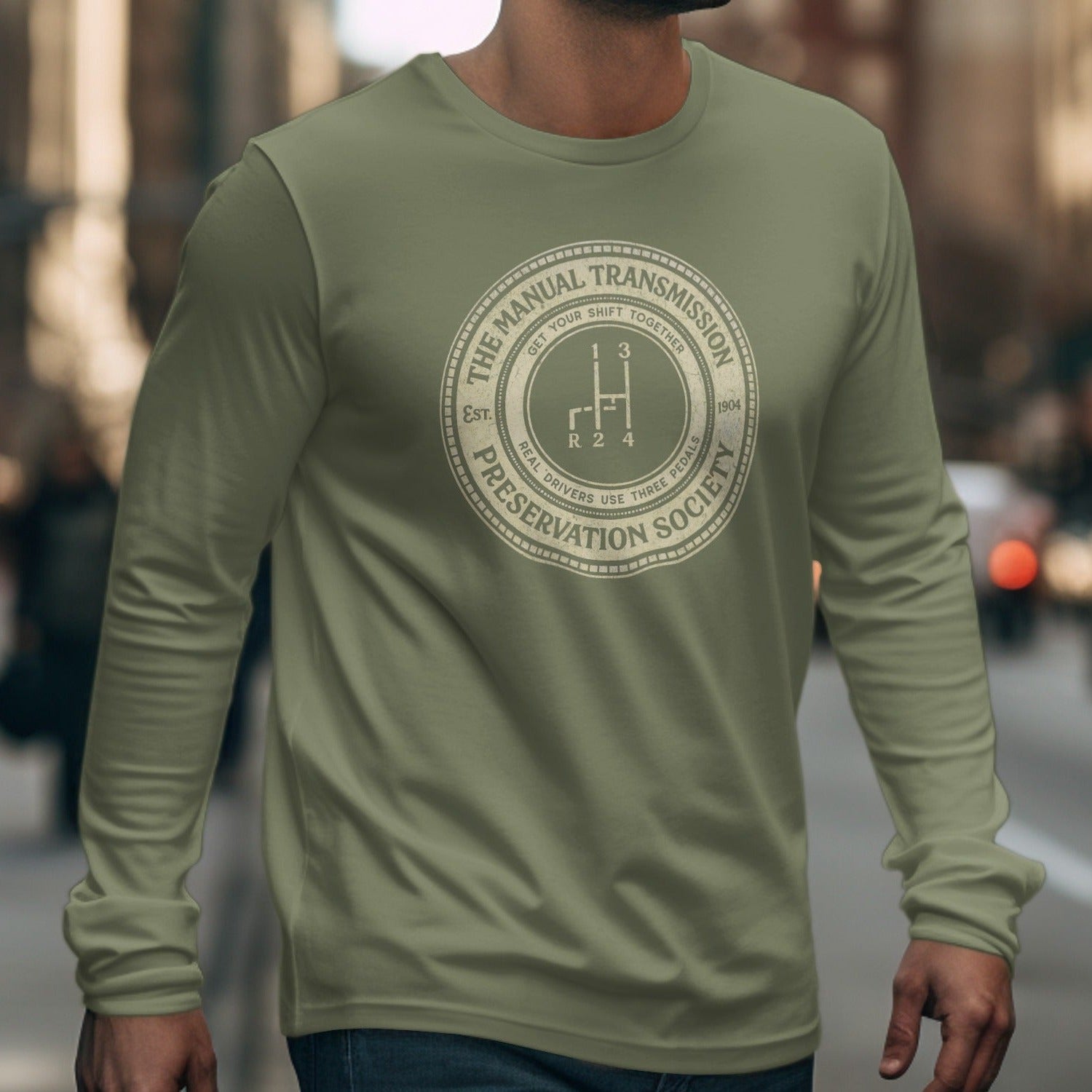 Men's olive long-sleeve shirt with "Manual Transmission Preservation Society" graphic.