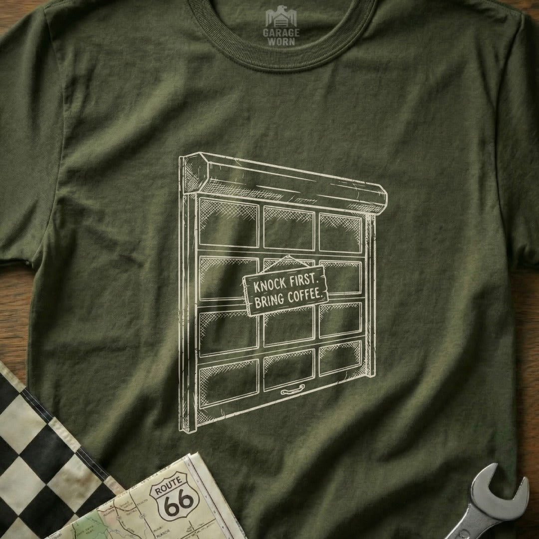 Garage door graphic with "KNOCK FIRST, BRING COFFEE" sign on t-shirt.