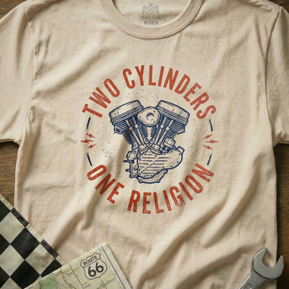 Cream t-shirt with "TWO CYLINDERS ONE RELIGION" and V-twin engine graphic.