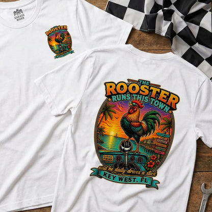 White t-shirt with a rooster on a stick shift at sunset in Key West, labeled "The Rooster Runs This Town."