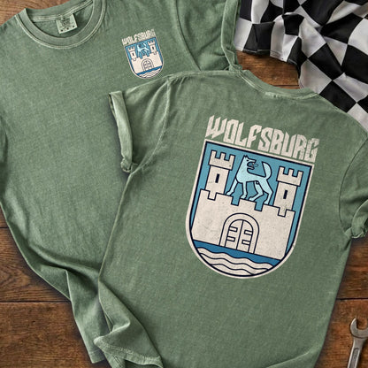 Green t-shirts displayed with "Wolfsburg" text and a crest featuring a castle and wolf.