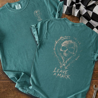 Teal t-shirt with a distressed skull and text that reads "LEAVE A MARK."