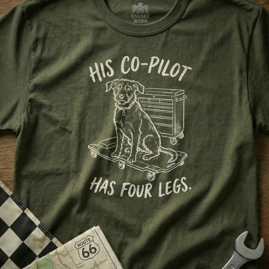 Green t-shirt with dog on a tool cart graphic and text "HIS CO-PILOT HAS FOUR LEGS."