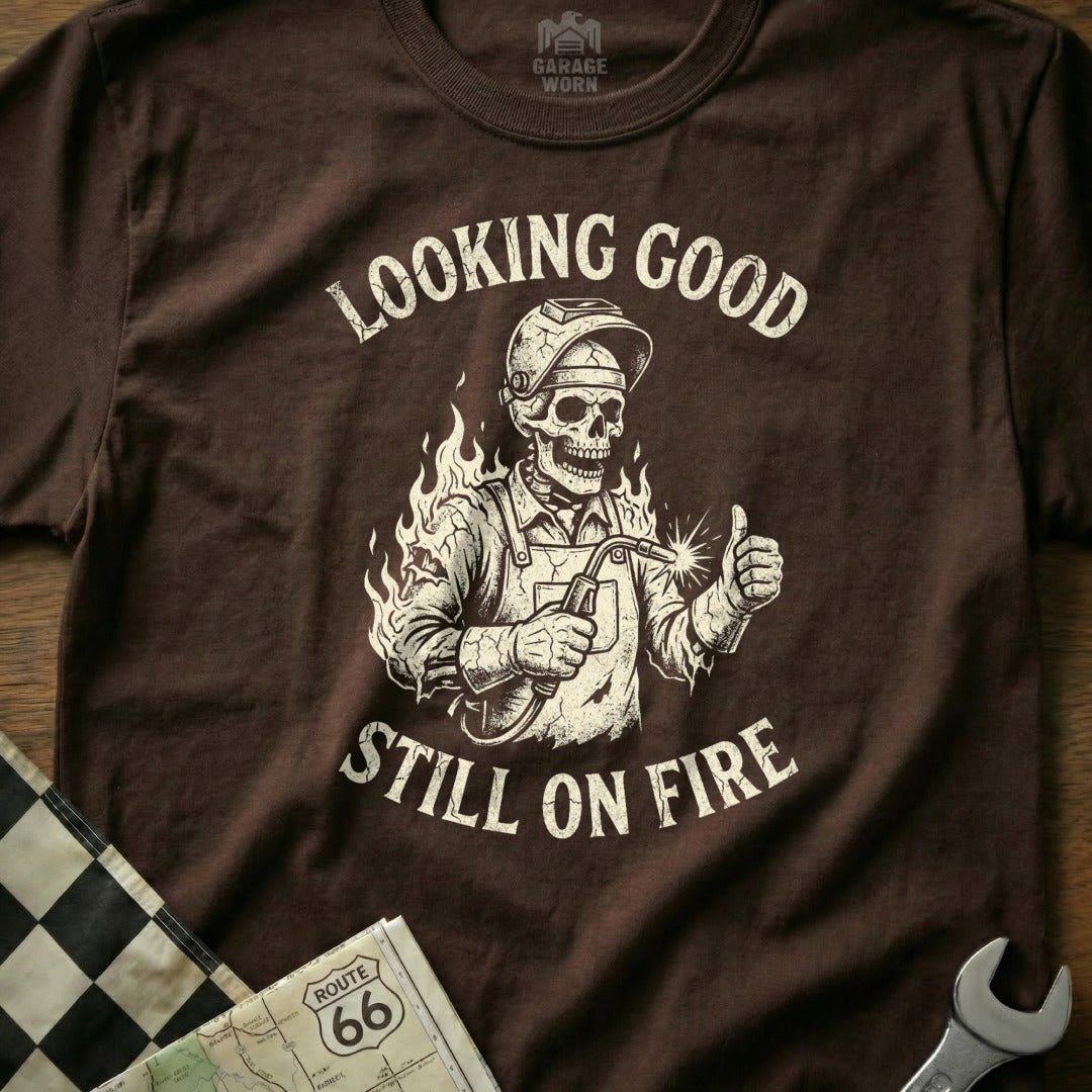 Skeleton welder giving thumbs up with "Looking Good Still On Fire" text.